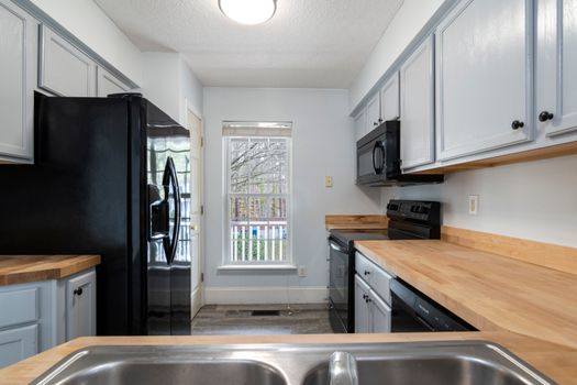 Bright and spacious kitchen featuring modern design with wooden countertops and stainless steel appliances.